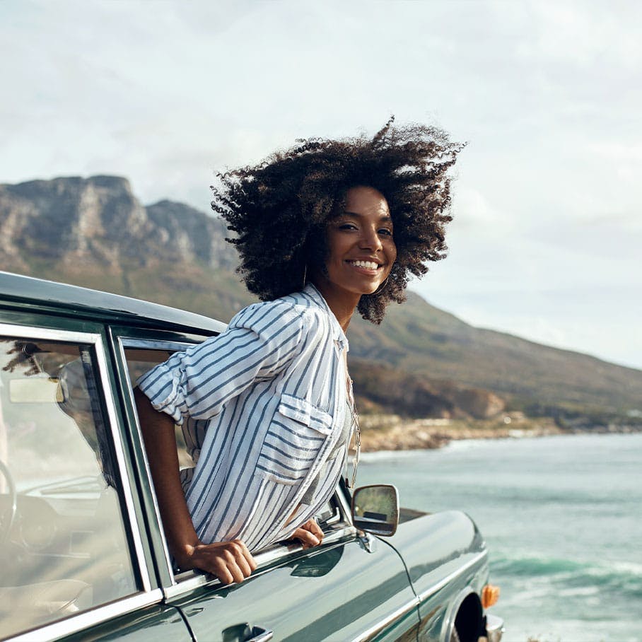 Smiling woman hanging outside car window after ExoMind treatment in Stamford, CT