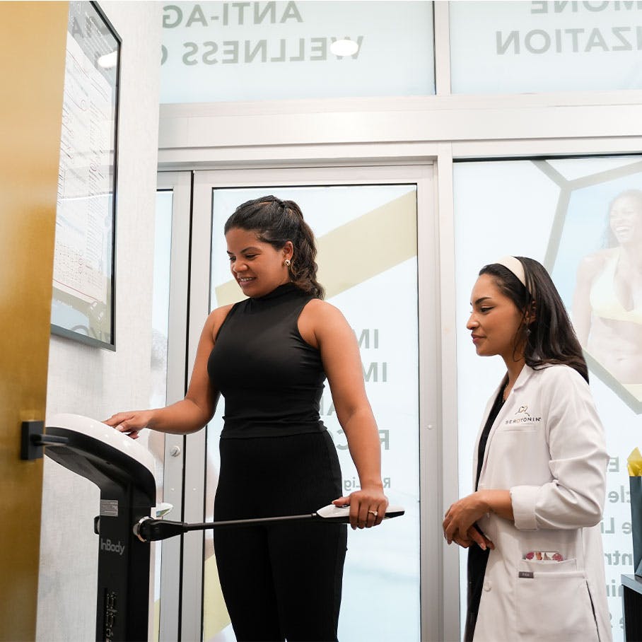 woman weighting herself on scale with weight loss coach in Del Mar, CA