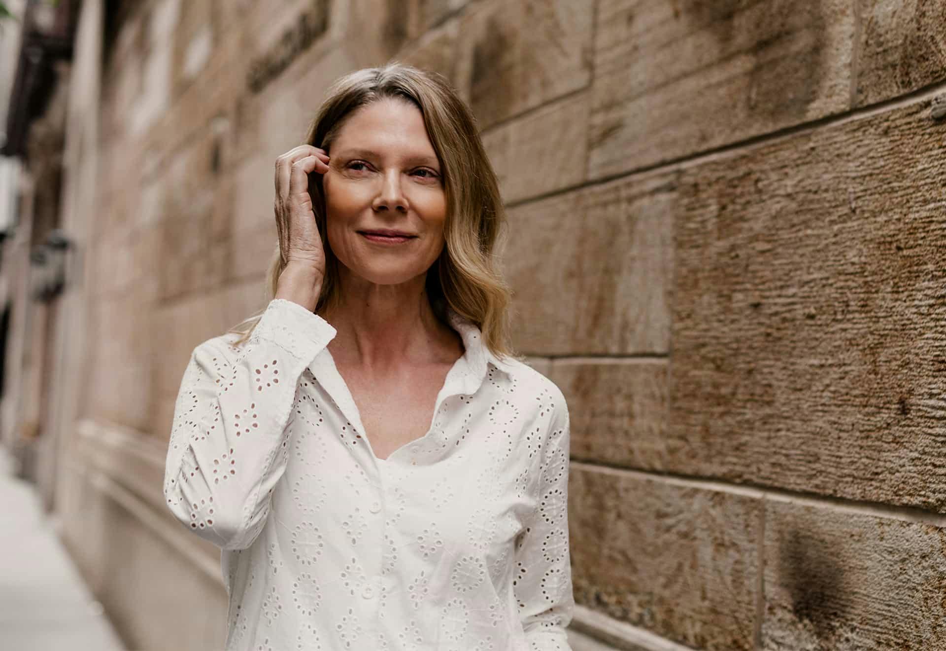 Woman walking down sidewalk smiling