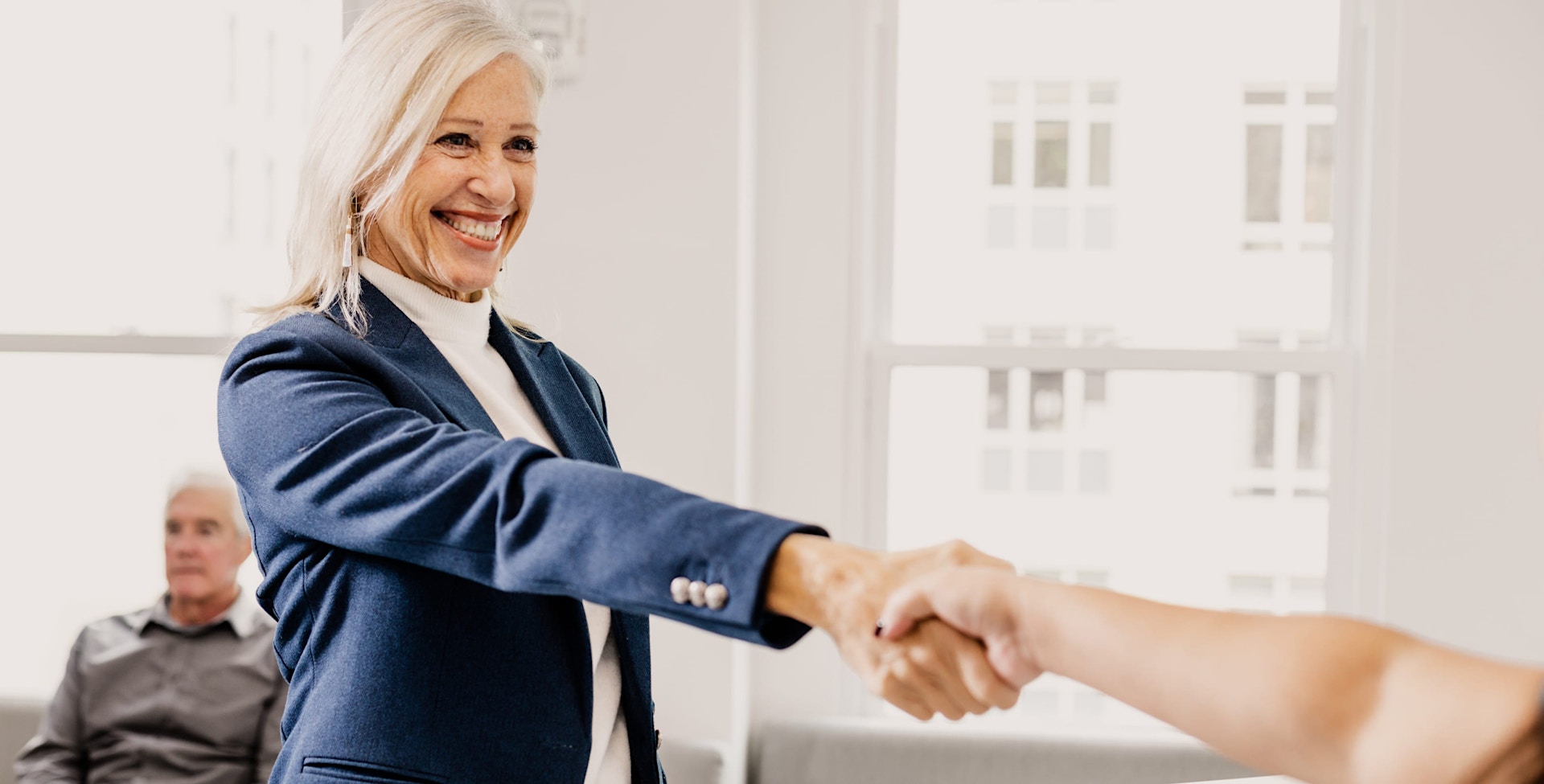 woman smiling shaking someones hand