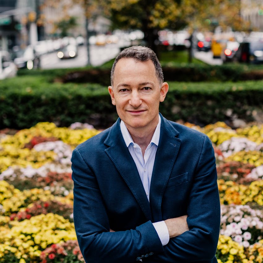 Dr Raviv smiling next to flowers