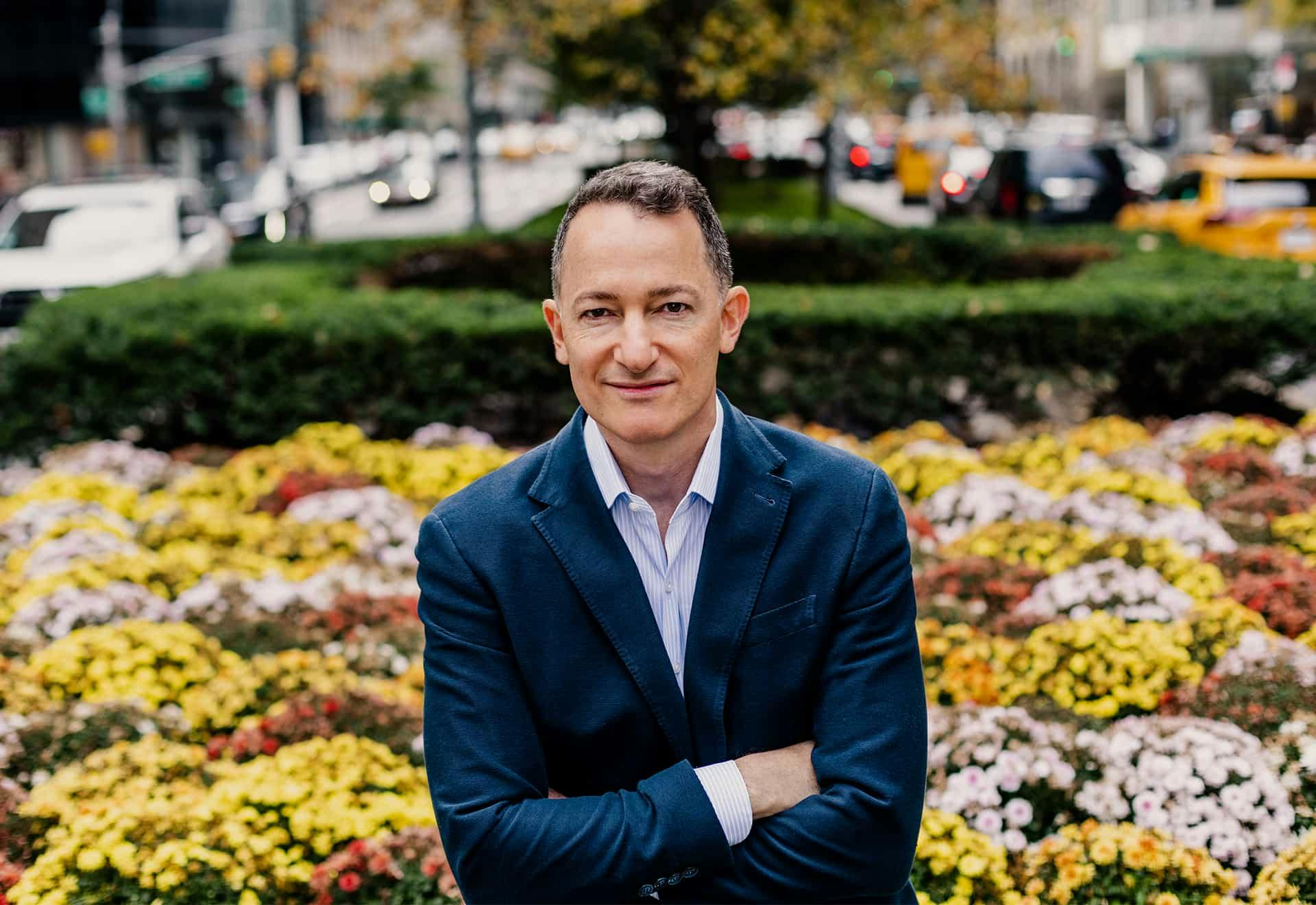 dr raviv standing with flowers behind him