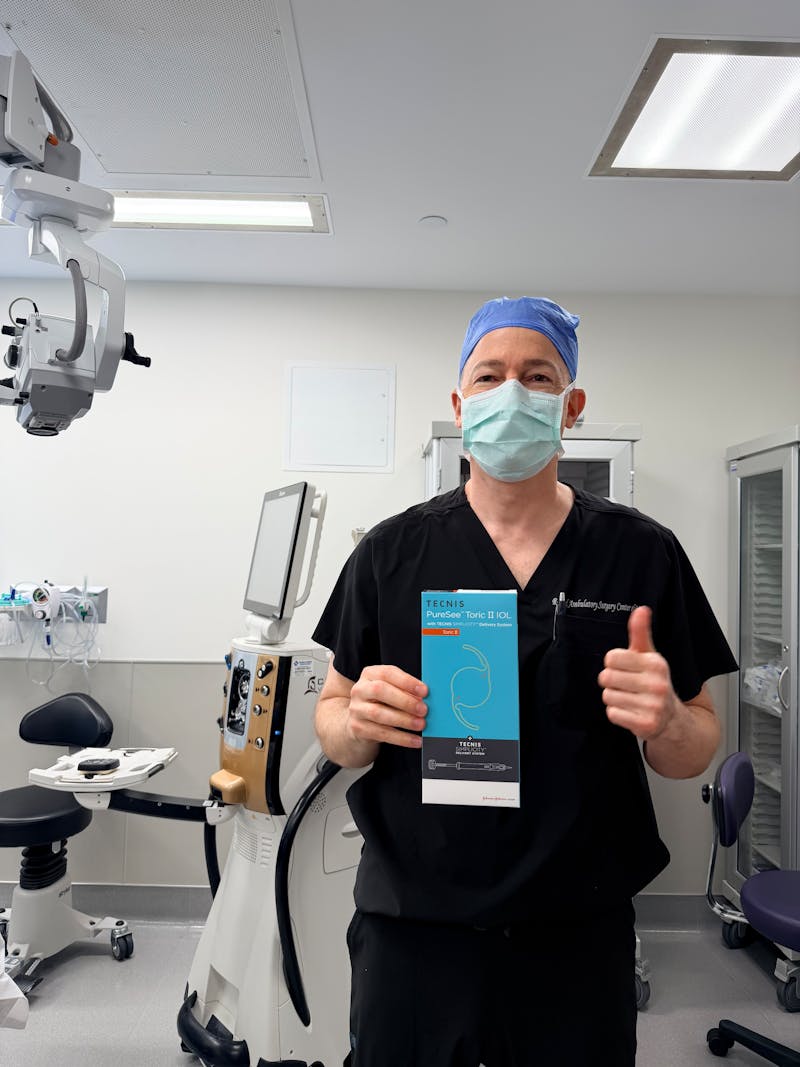 Dr. Raviv holding s TECNIS PureSee pamphlet