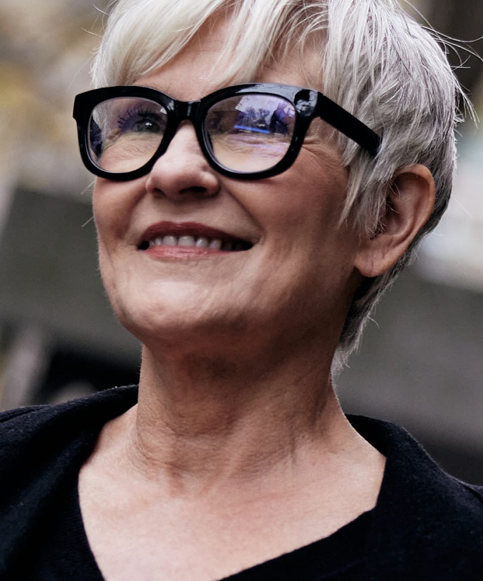 older woman with short hair wearing glasses