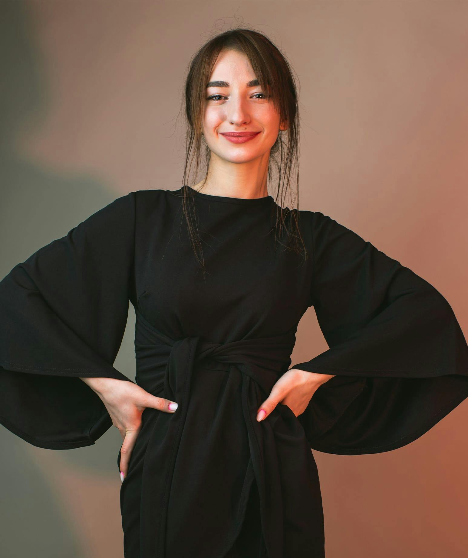 smiling woman standing with her hands on her hips