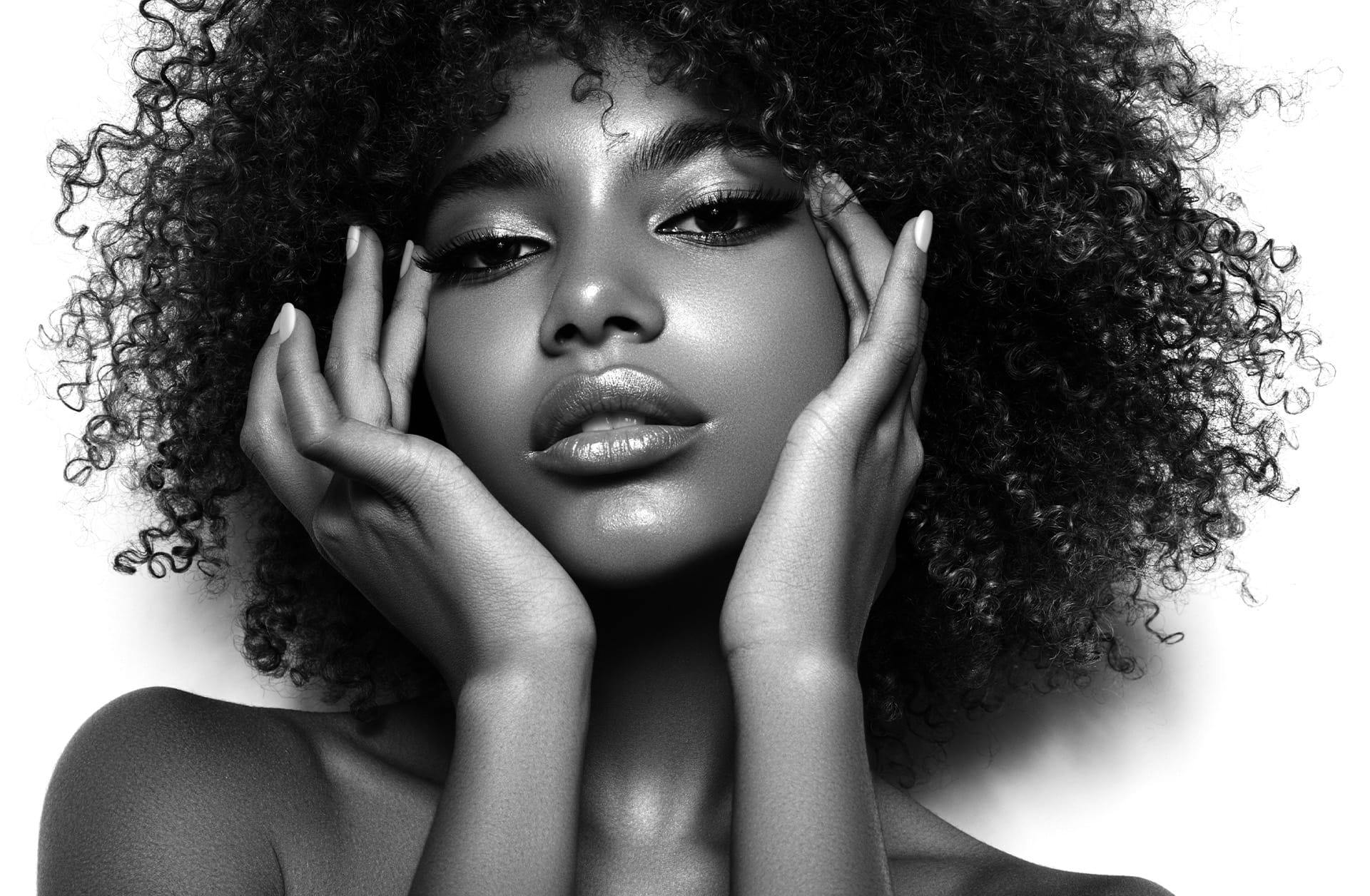 black and white photo of a woman touching her face