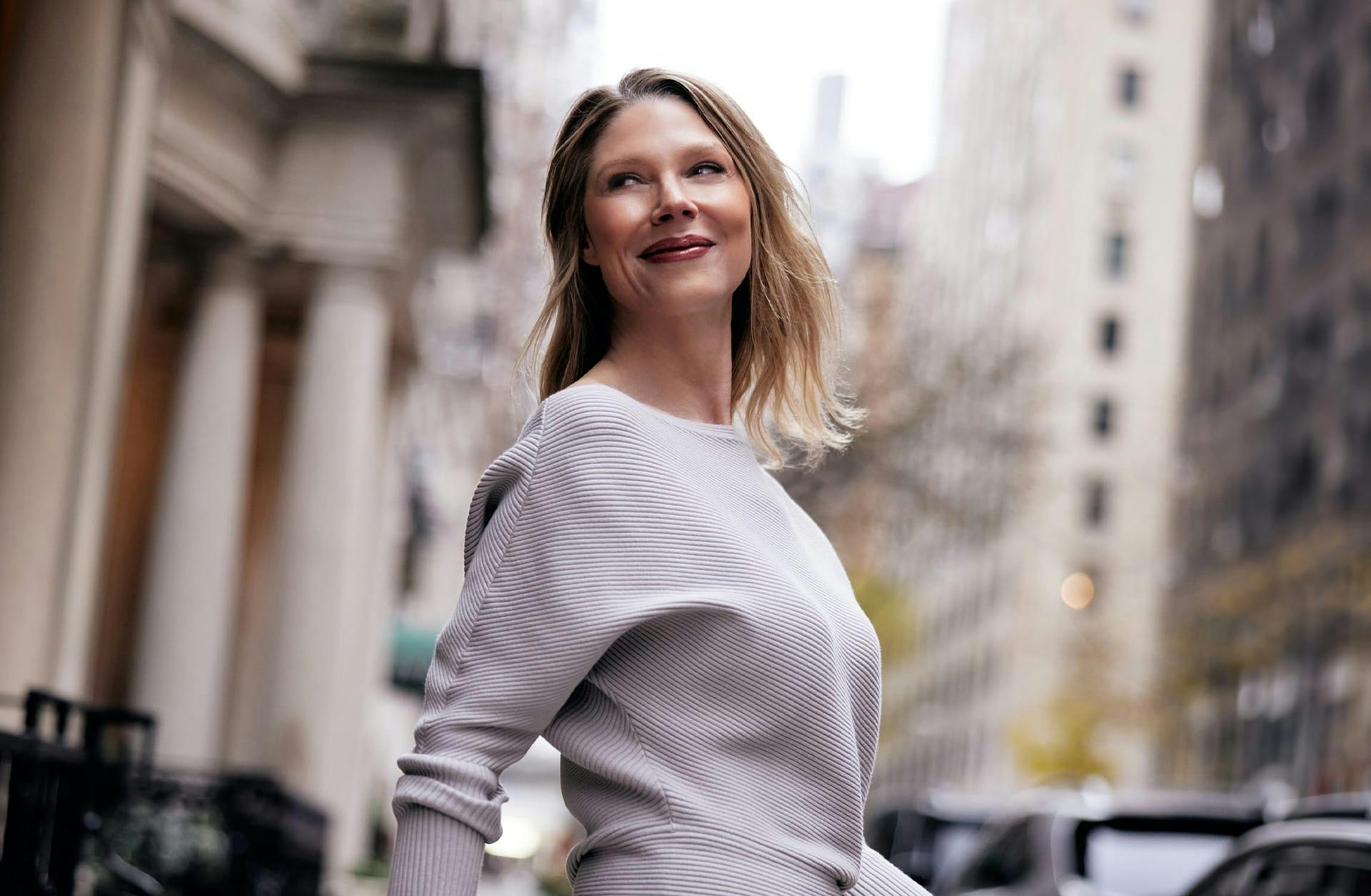 woman walking outside, smiling over her shoulder