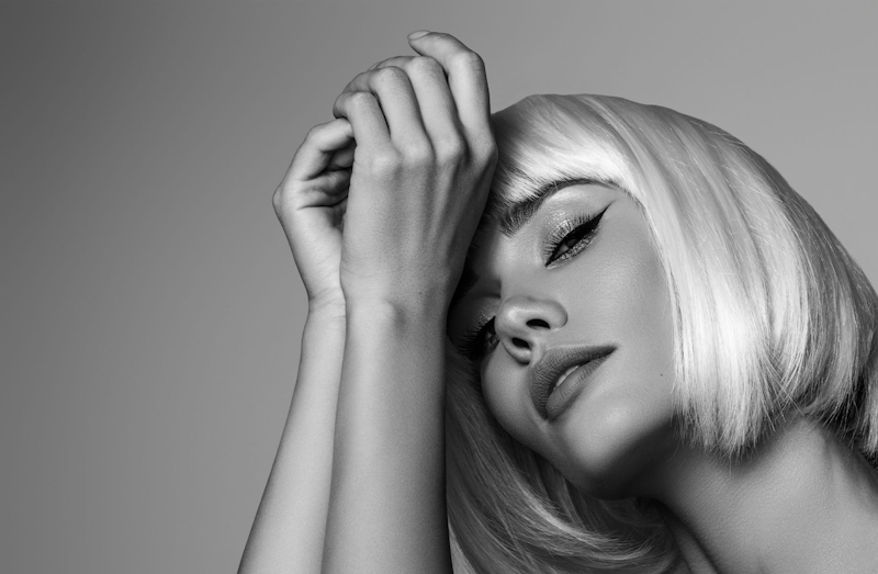 black and white photo of a woman leaning her head against her hands