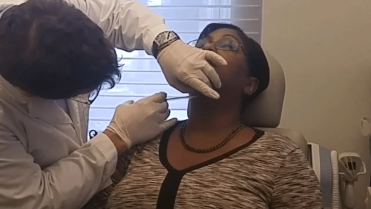 woman receiving an injection on her neck by Dr. Westreich
