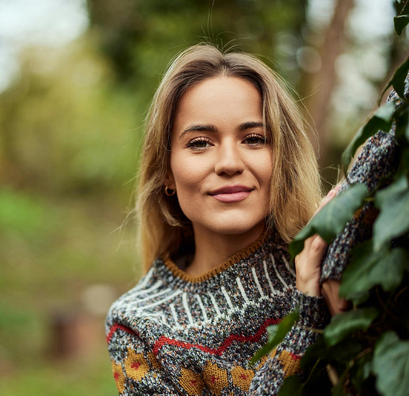 woman posing behind a tree