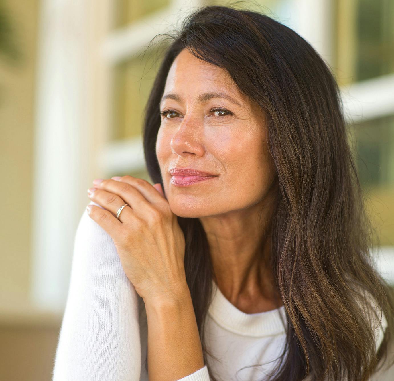 older woman looking in distance with her hand on her shoulder