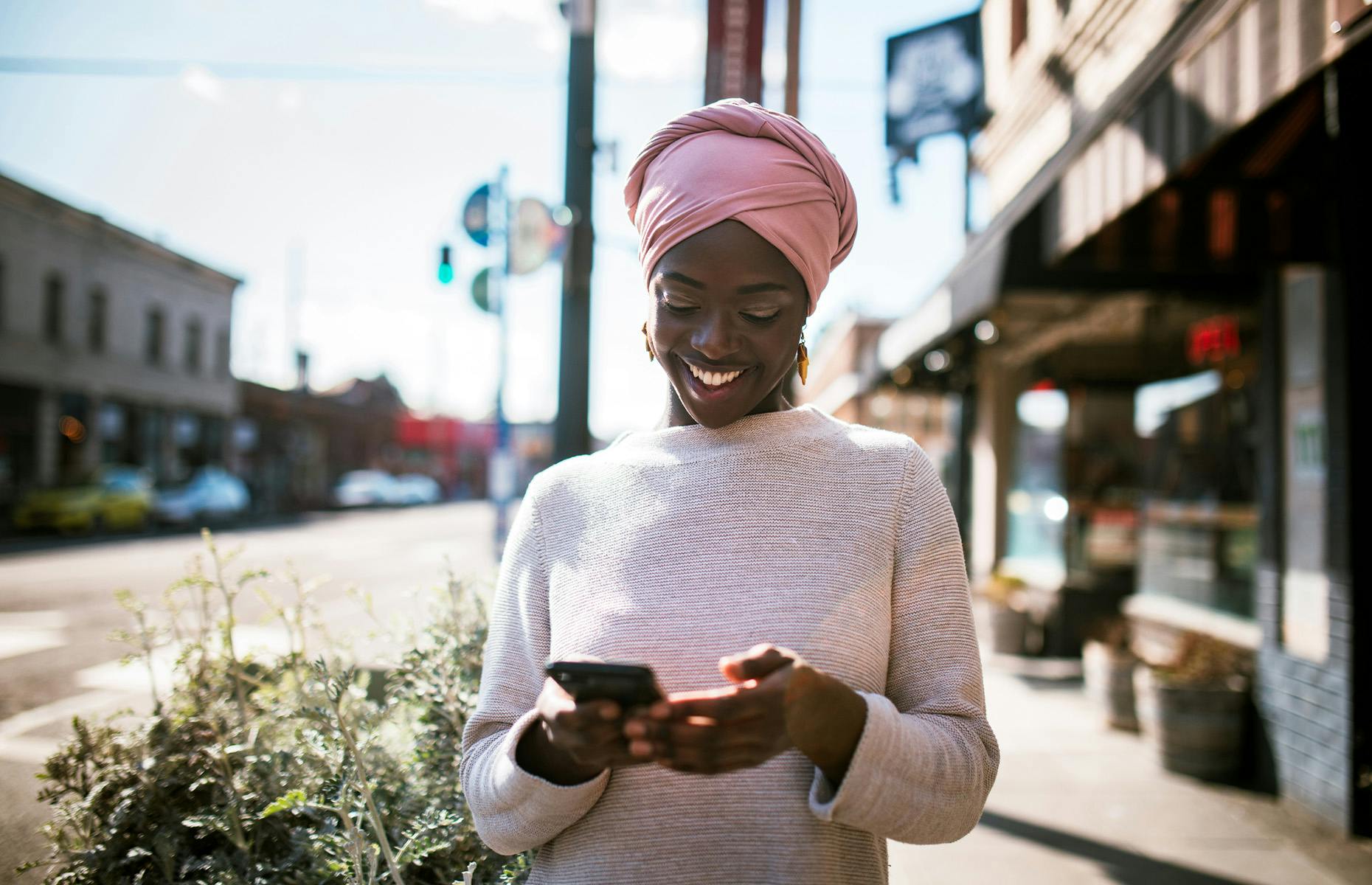 lady walking on sidewalk looking at her phone