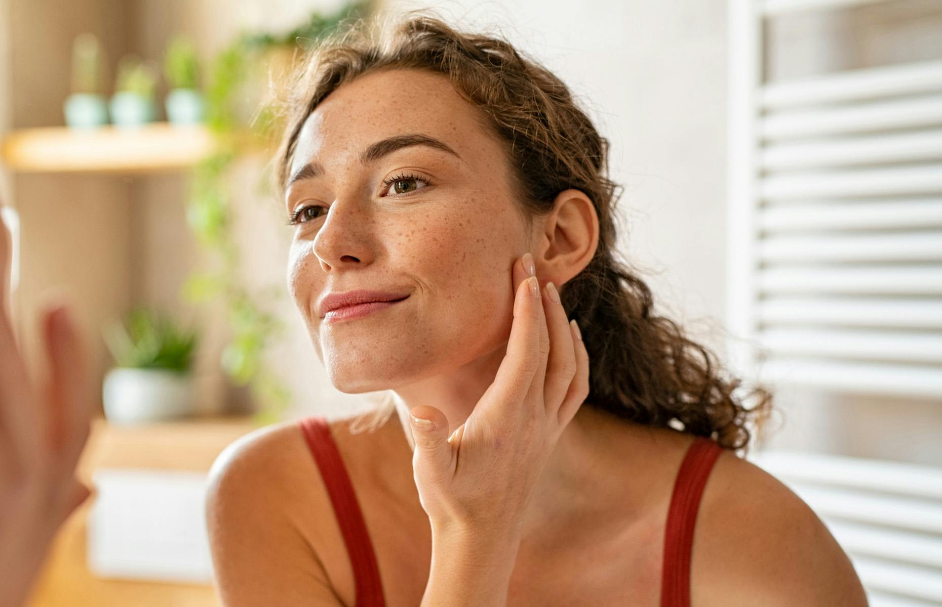 lady looking into mirror touching her jaw