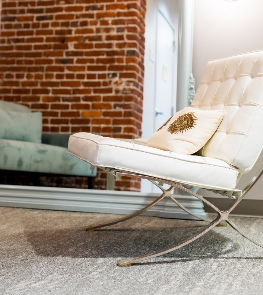 a white couch with brick wall in background
