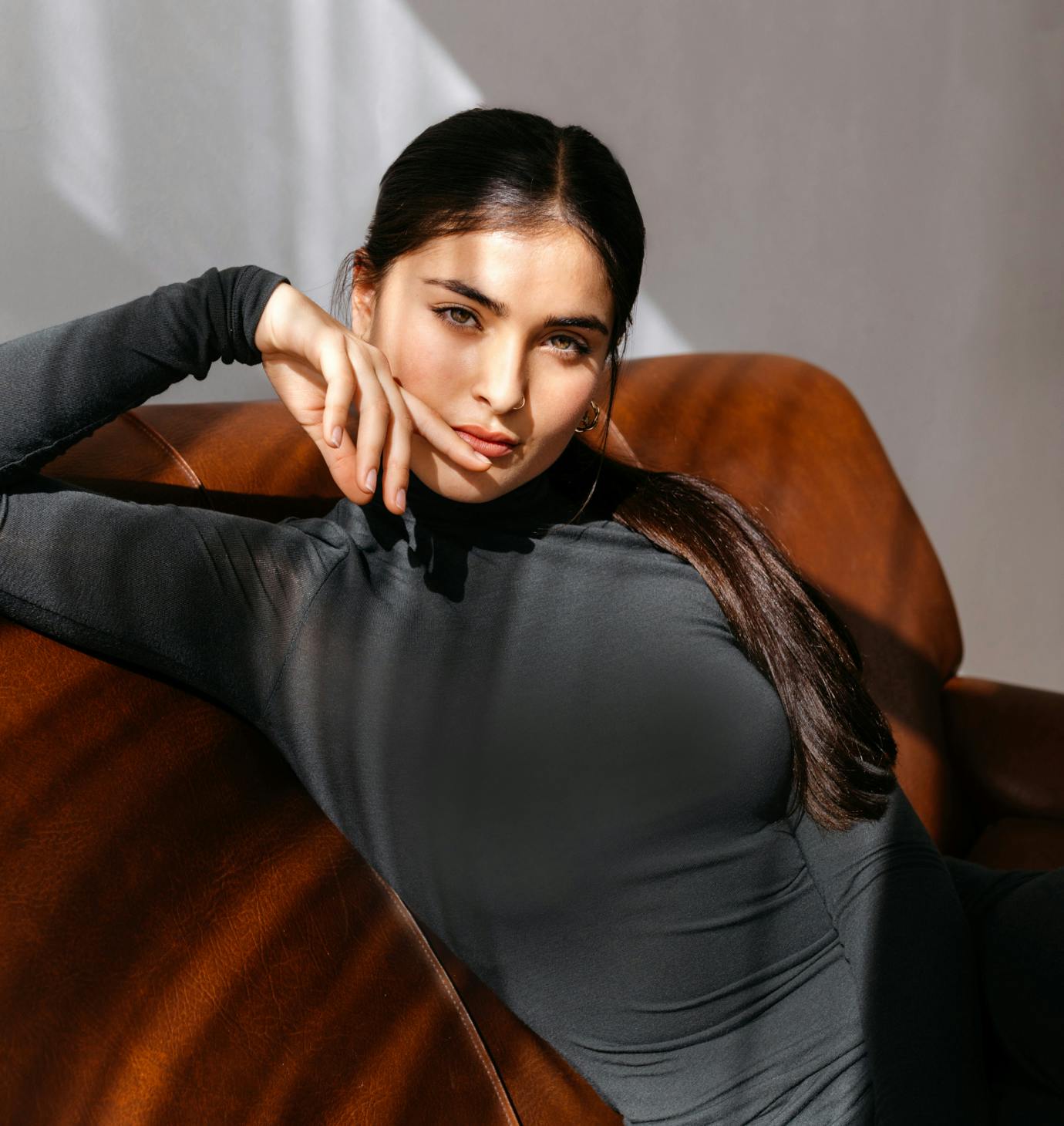 lady in black long-sleeve laying on orange sofa