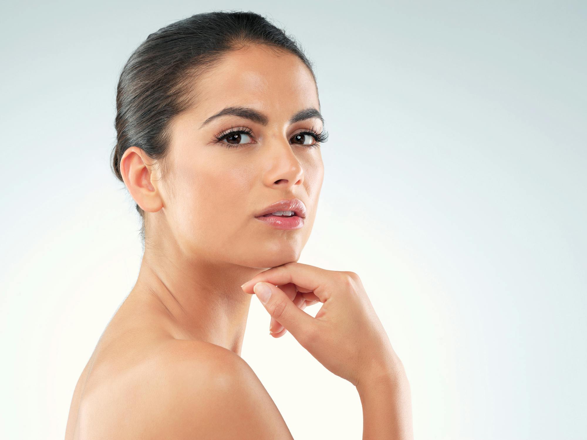 woman with clear skin holding her chin