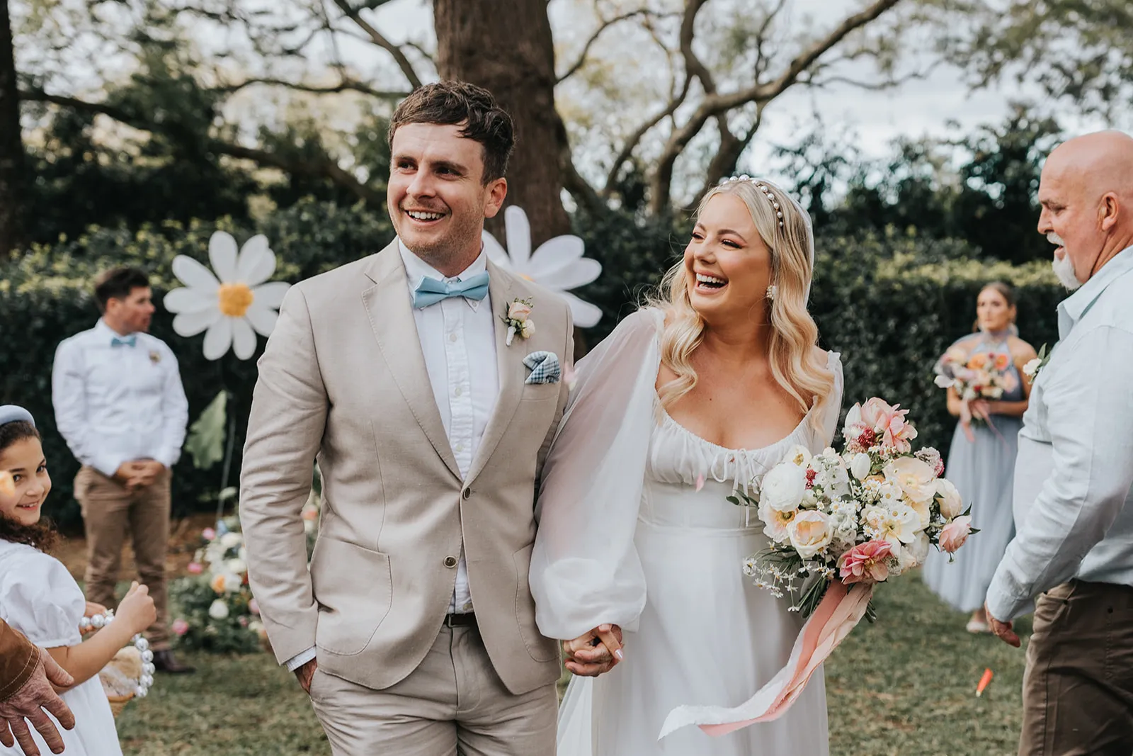 Bride and groom walking down the aisle laughing