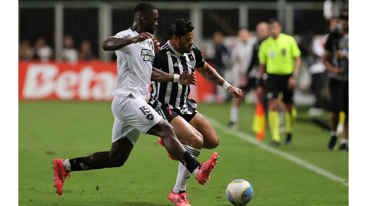 Jogador do Botafogo disputando a bola contra Hulk, do Atlético-MG