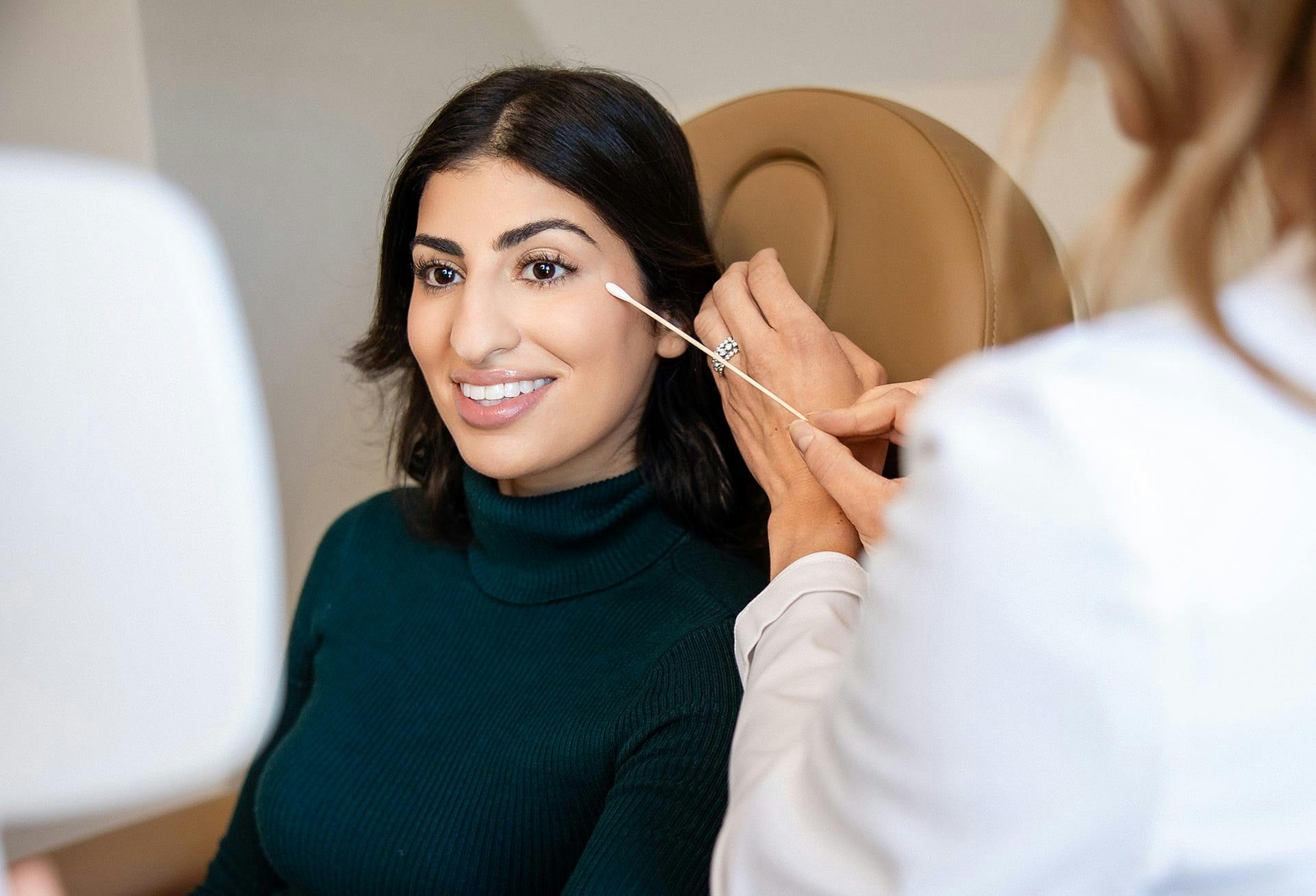 doctor putting q-tip to client's face