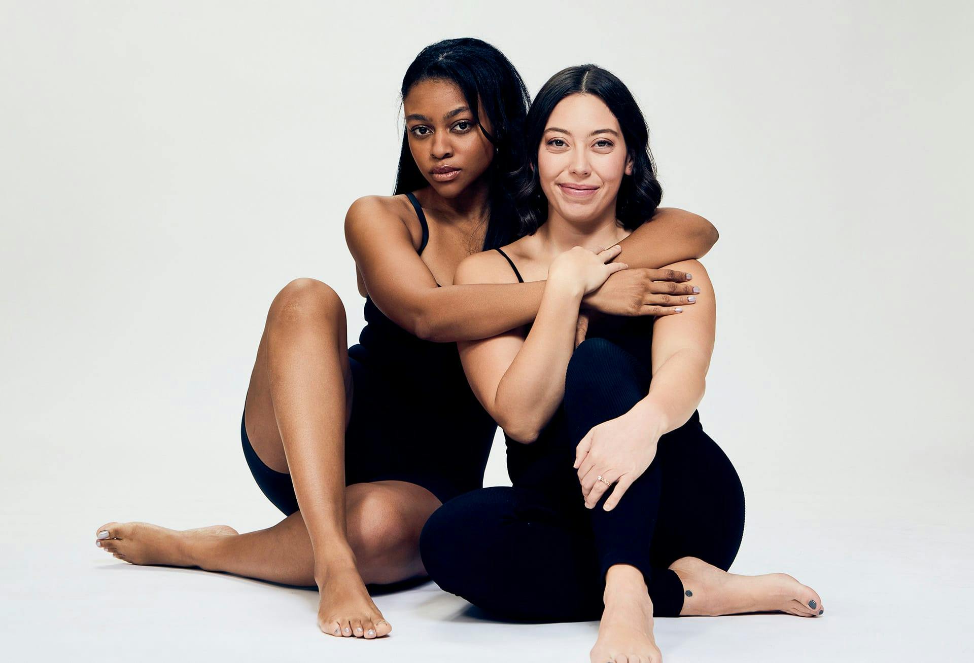 2 women posing on floor together