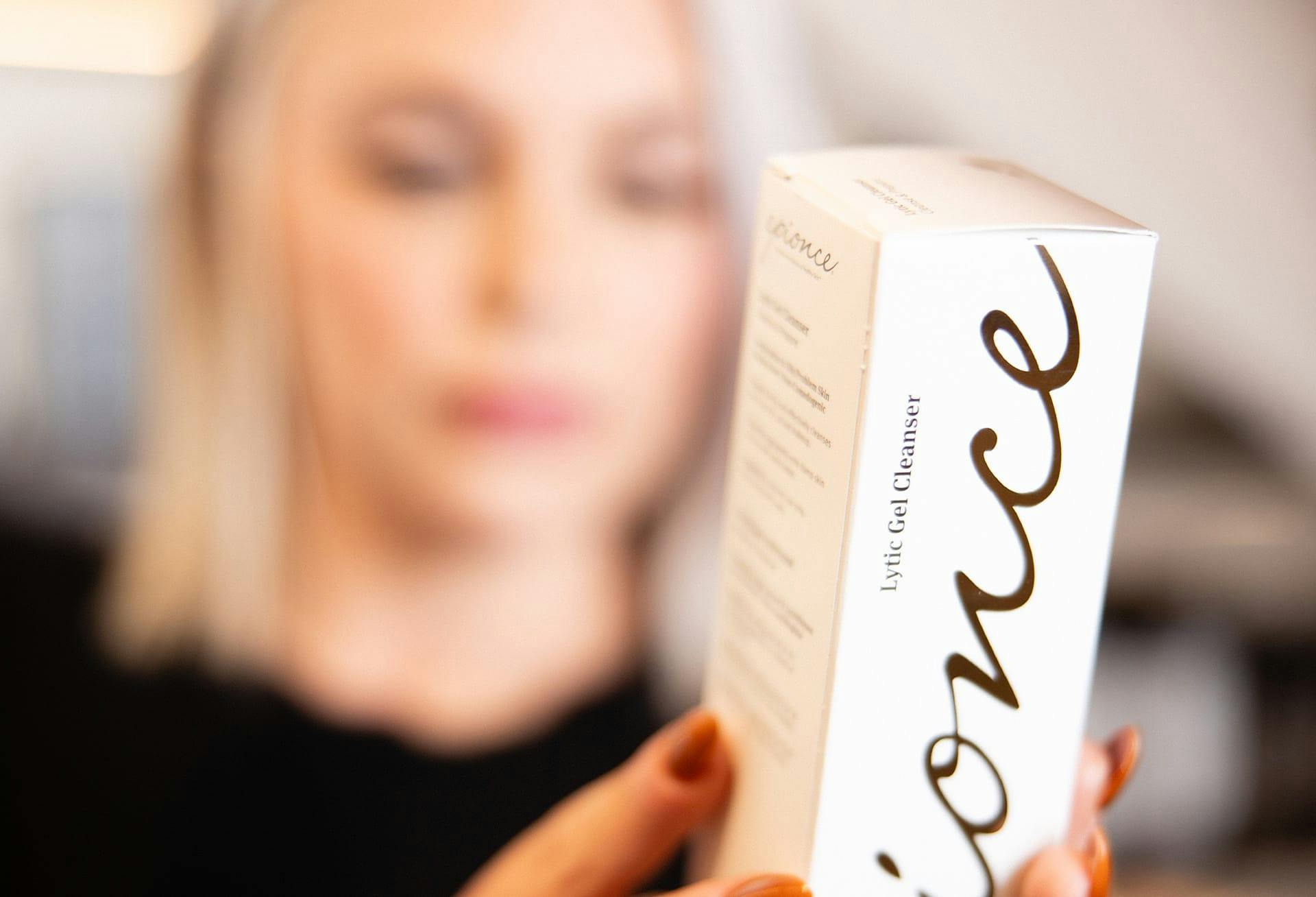 close up of epionce cleanser with lady holding it