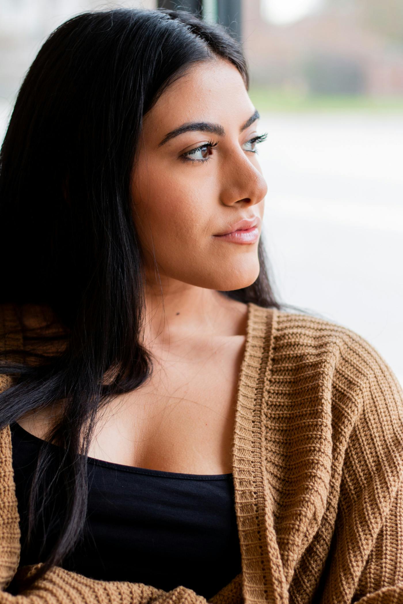 woman wearing a brown sweater looking to the side