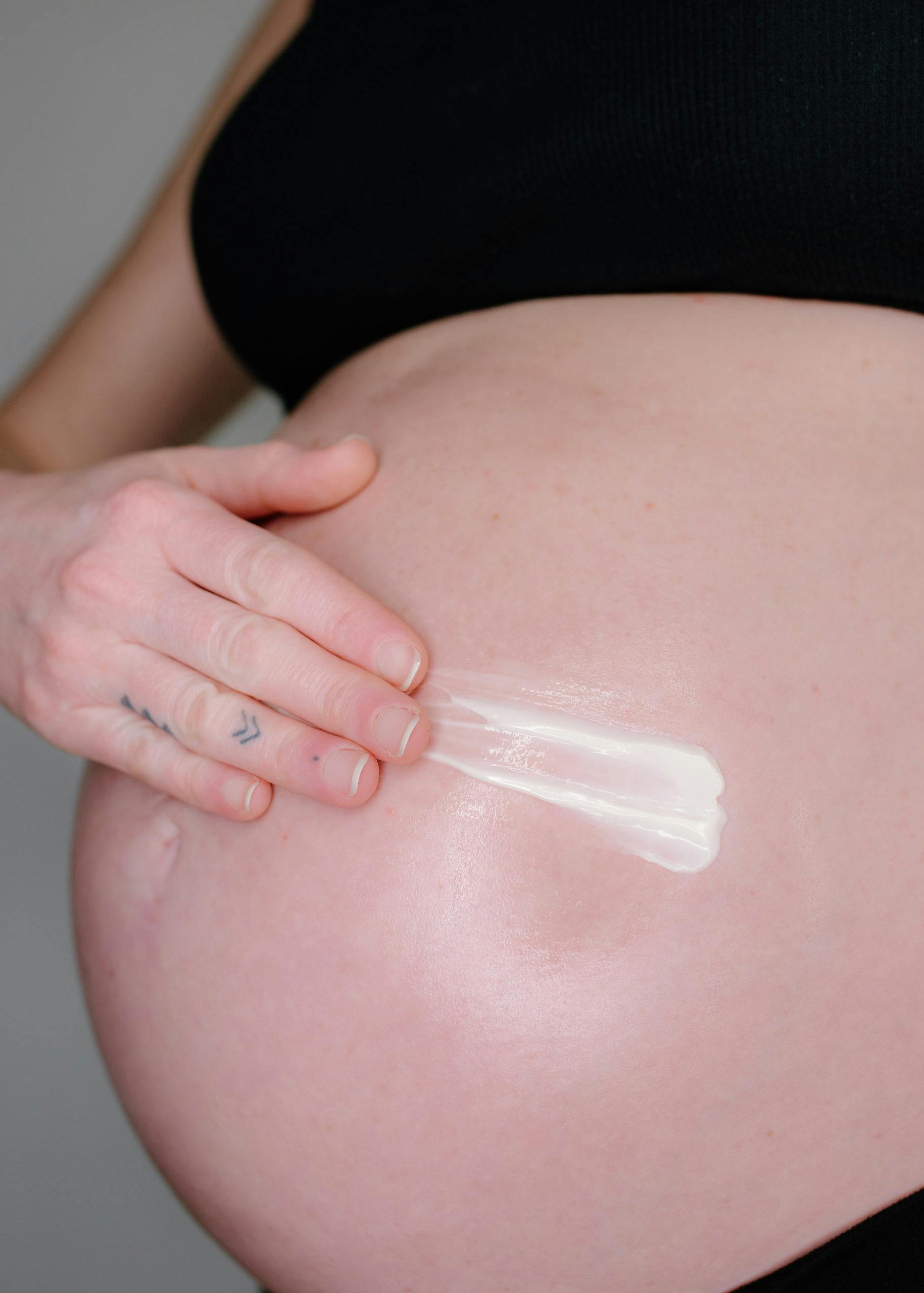 woman moisturizing her stomach