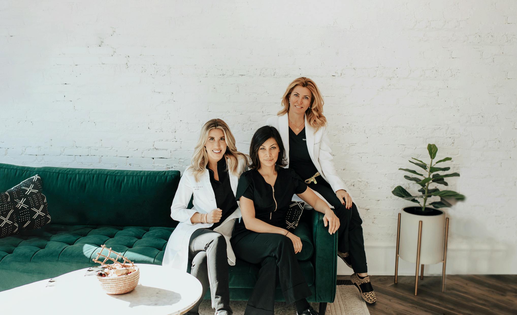 group of women sitting on a green couch