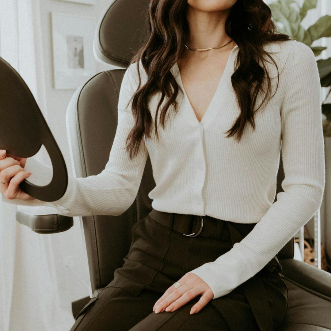 woman looking into a handheld mirror