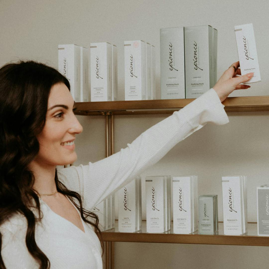 woman grabbing skincare product off a shelf