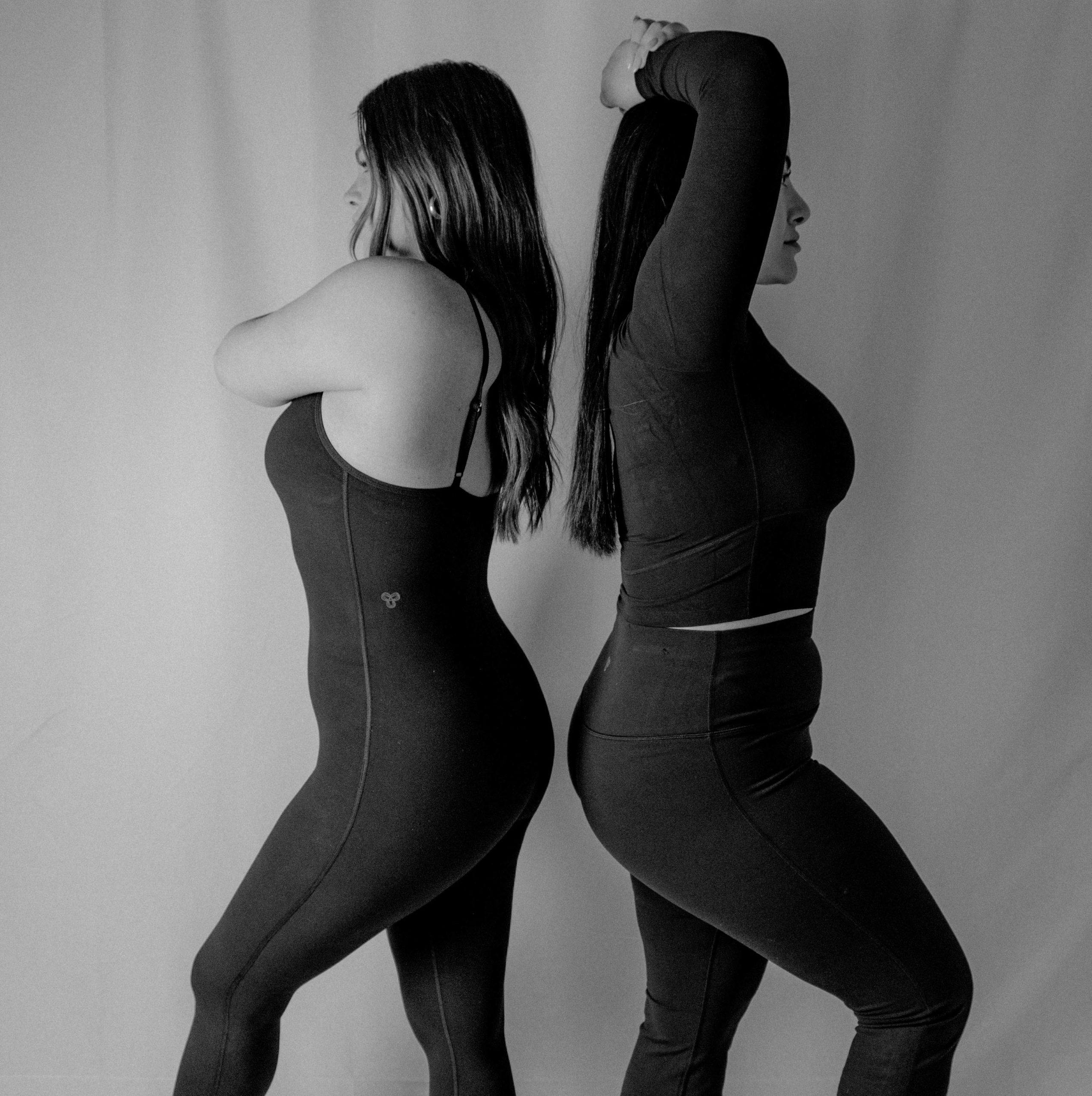 two women standing back to back