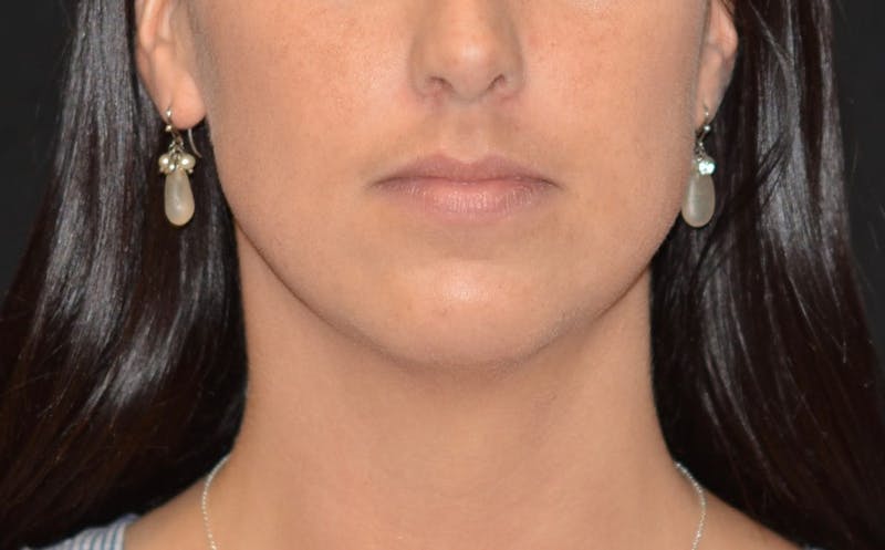 a close up of a woman with a necklace and earrings