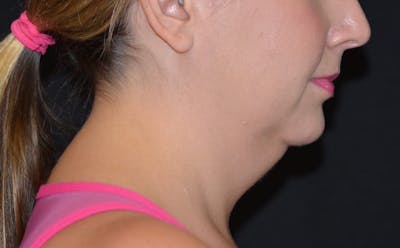 a close up of a woman with a ponytail and a pink top