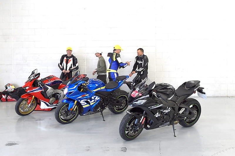 Honda, Suzuki and Kawasaki in a pit garage
