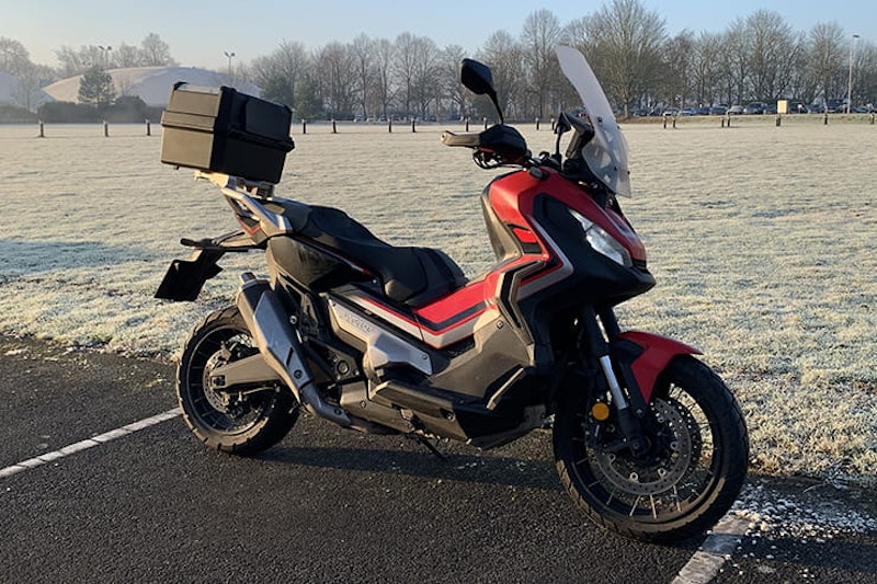 Honda’s 750cc, 75mpg adventure commuter scooter continues to defy convention. But we love it all the same