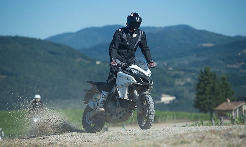 Tall man rides tall bike in tall mountains.