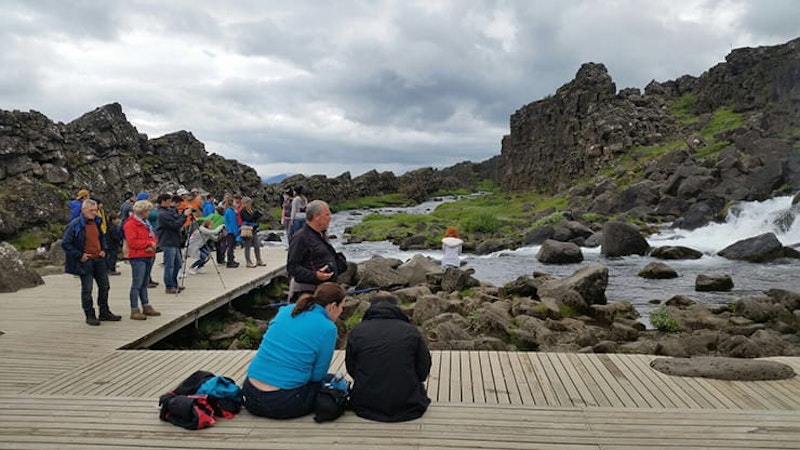 people sat around a hot pool in Iceland