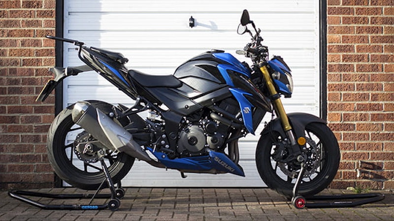 blue motorbike stored on paddock stands for the winter