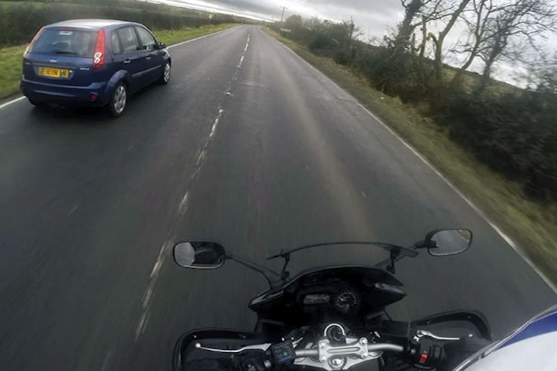 A motorcycle overtakes a car