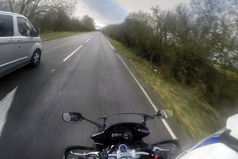 A motorcycle overtakes a van