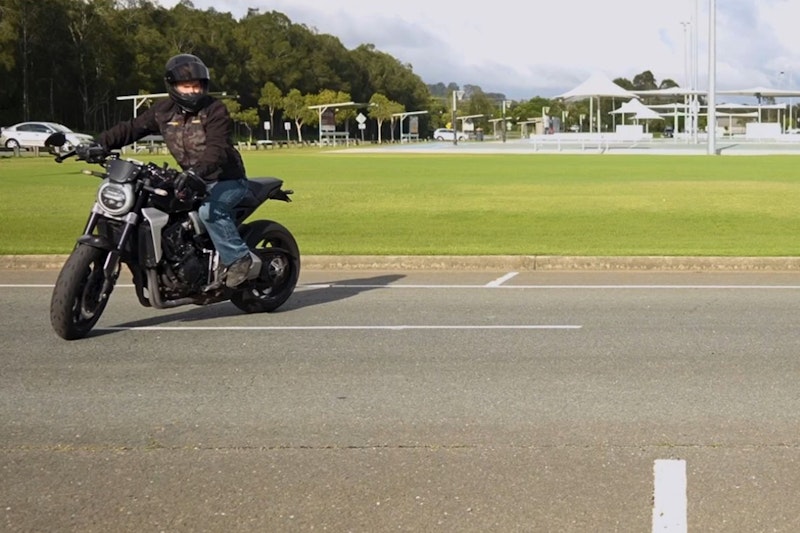 A motorcycle rider demonstrates slow speed control in a concentric circle