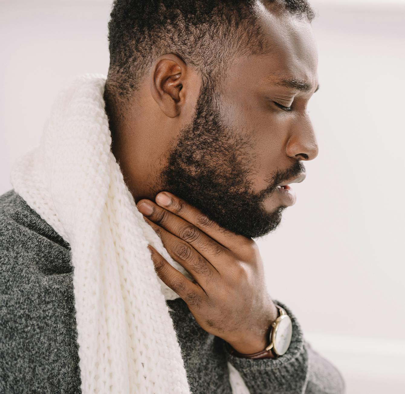 man holding his throat in discomfort