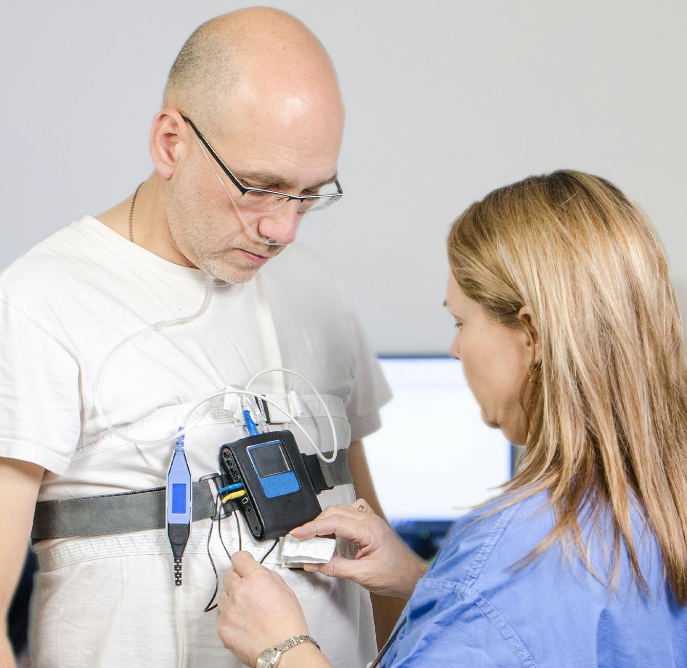 person getting ready for sleep apnea testing with a doctor