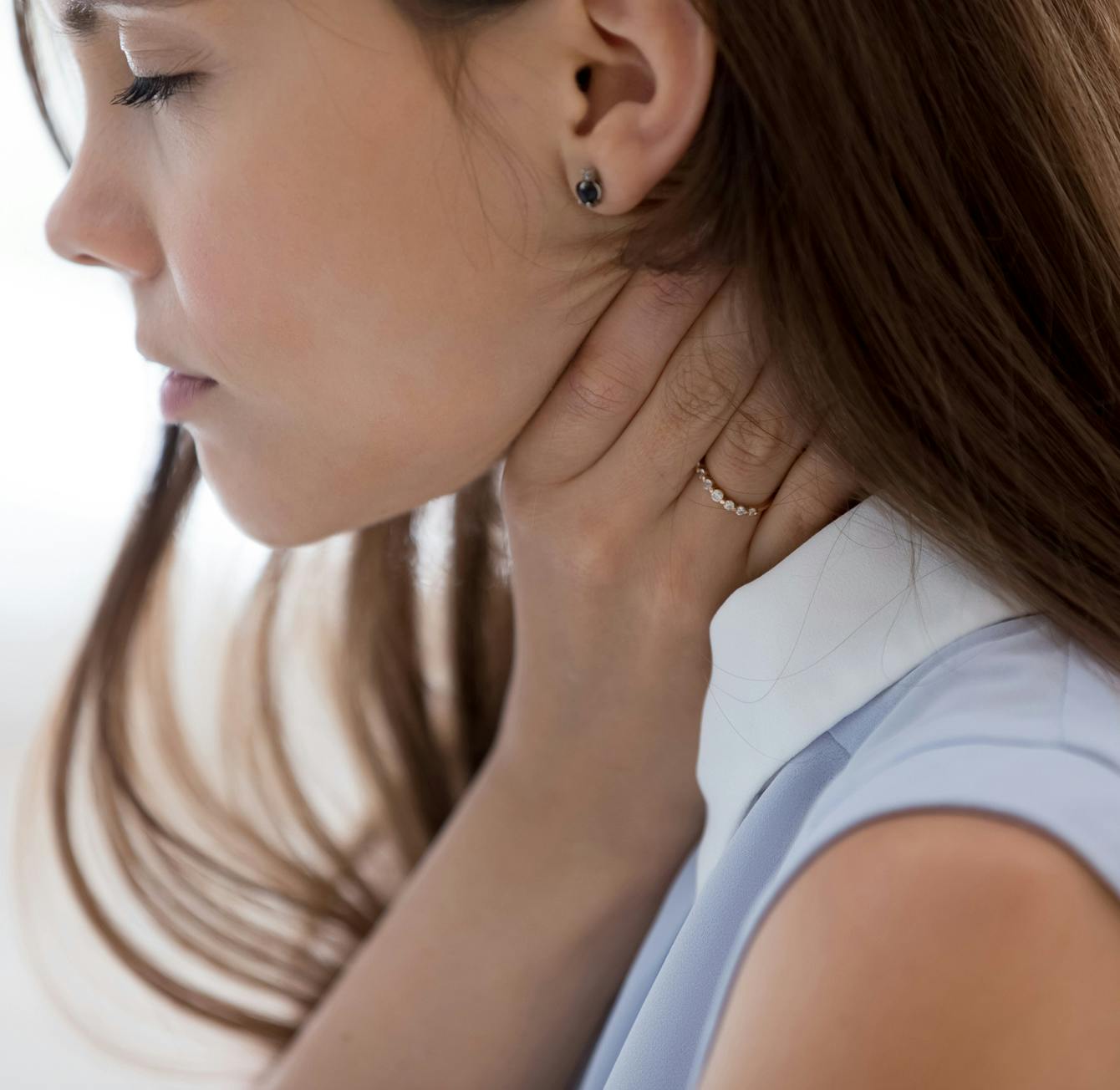 woman touching her throat in discomfort