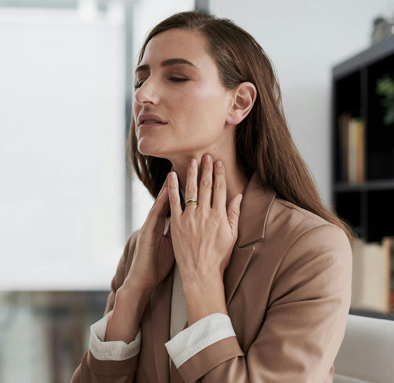 woman touching her neck in discomfort