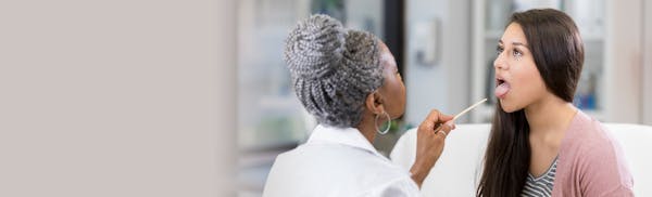 doctor checking patients tonsils