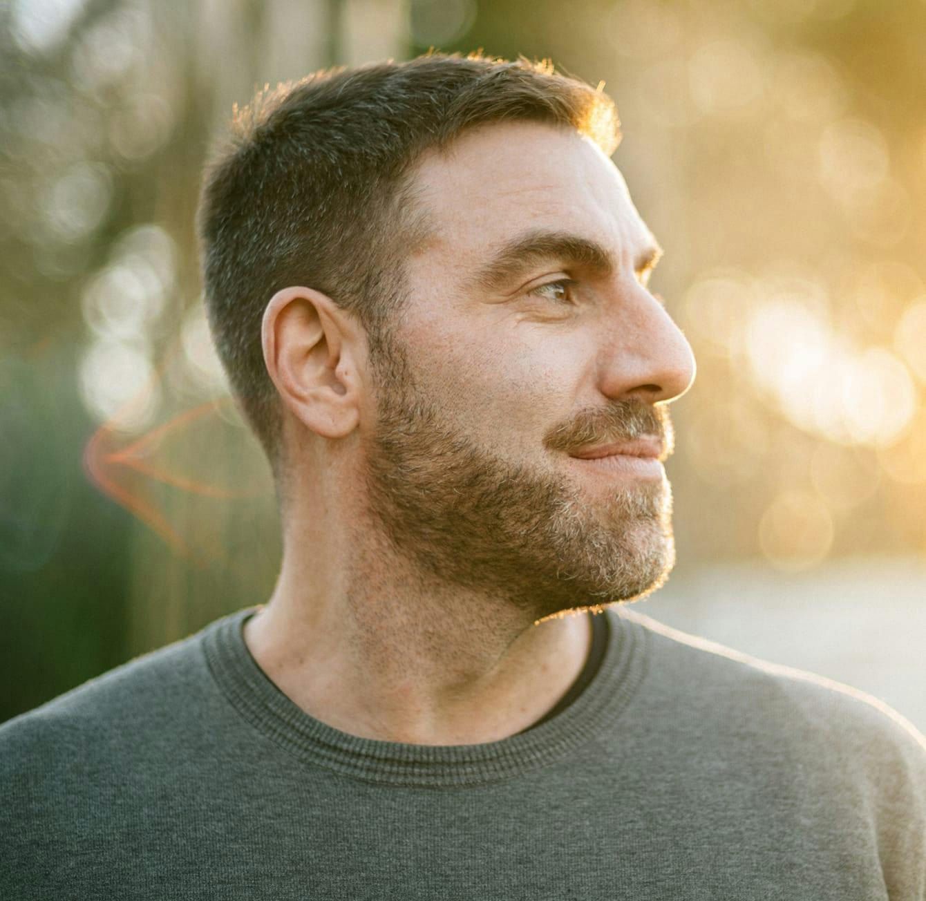 man with facial hair looking to the side