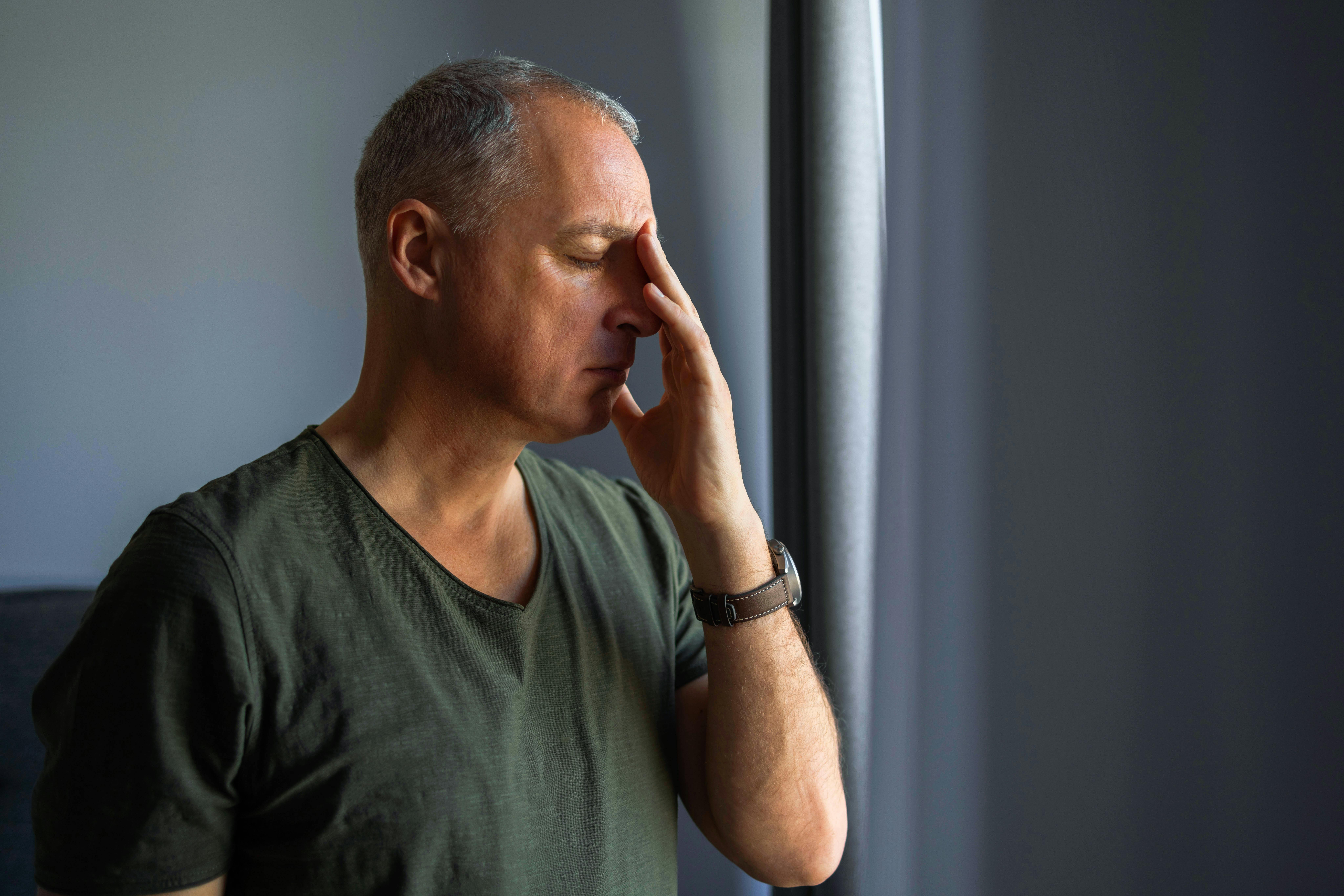 man holding his face