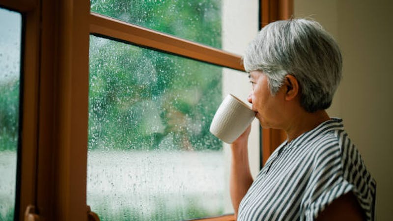 Woman Looking at the Rain Outside of the Window