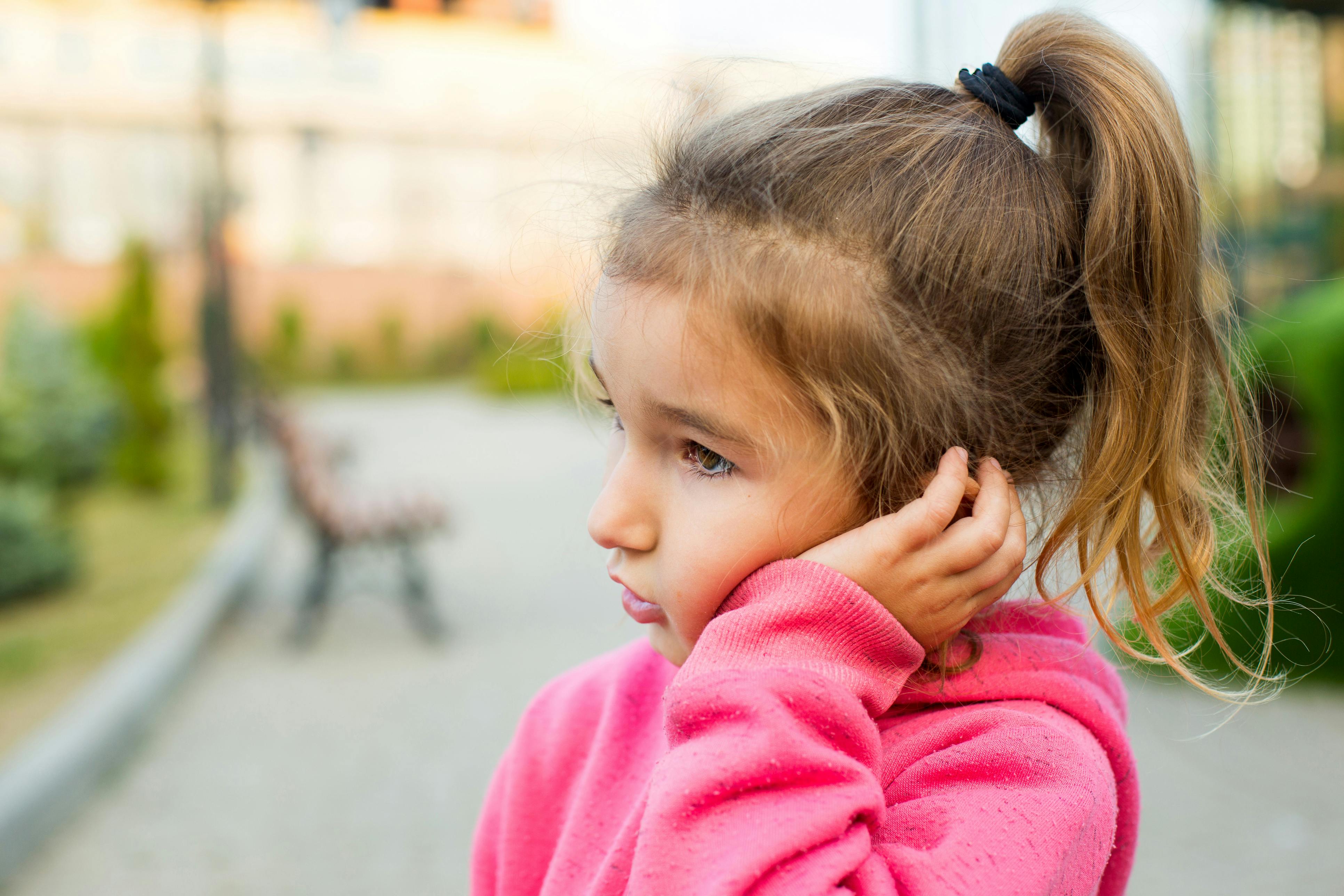 Child holding her ear